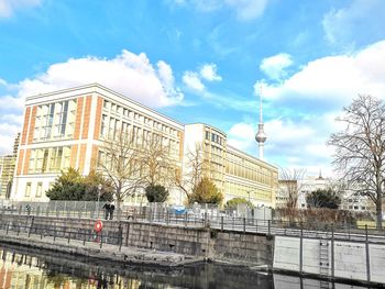 View of bridge and buildings against cloudy sky