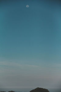 Low angle view of moon in blue sky