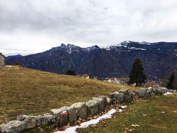 Scenic view of field and mountains against sky