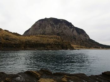 Rock formations by sea against sky