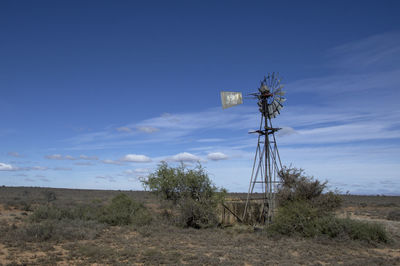 Windmill on field against sky
