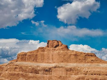 Low angle view of rock formations against cloudy sky