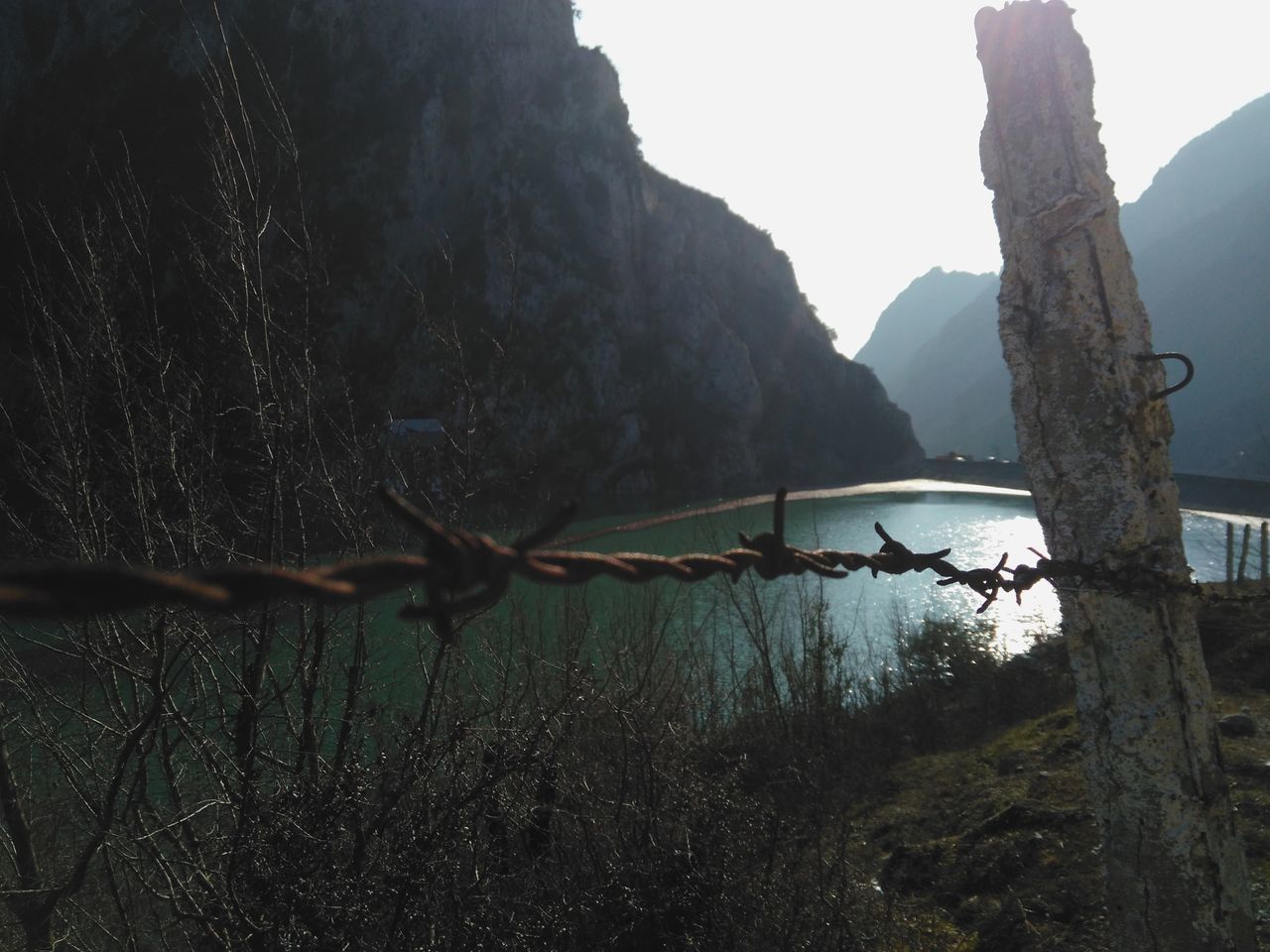 mountain, nature, outdoors, beauty in nature, protection, barbed wire, day, scenics, tranquility, no people, tree, sky, water, dead tree