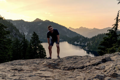 Portrait of mature man standing on mountain against sky during sunset