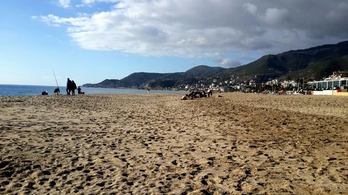 Scenic view of beach against cloudy sky