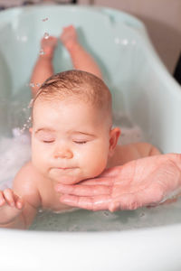 Portrait of cute baby boy in bathroom