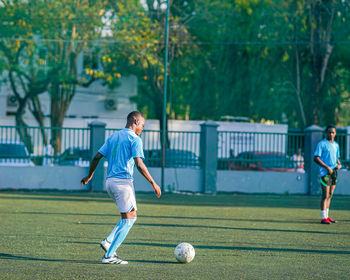 Full length of boy playing soccer at park