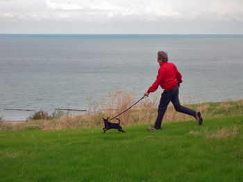 Man with dog running at beach