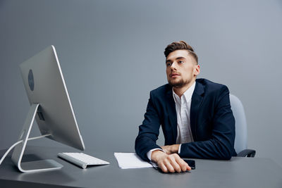 Portrait of businessman using laptop at office