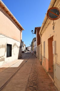 Footpath amidst buildings against sky