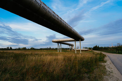 Metallic structure on field against sky