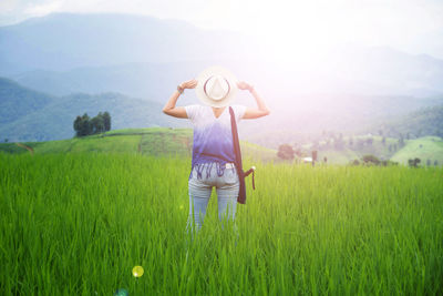 Rear view of a woman standing in field