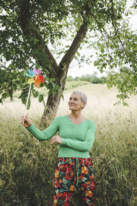 Young woman with arms outstretched standing on field