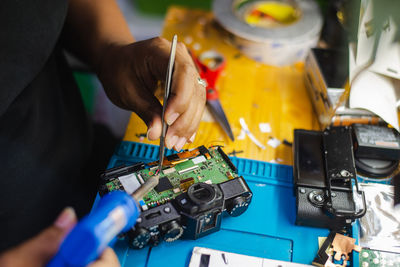 Midsection of woman repairing computer equipment