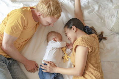 Rear view of mother and son on bed