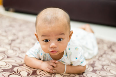 Portrait of cute baby lying on bed