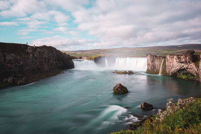Scenic view of waterfall against sky
