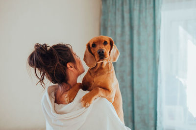 Woman with dog sitting at home