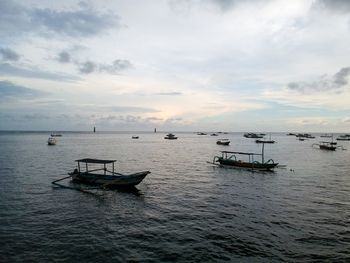 Boat in sea against sky during sunset