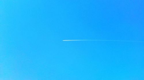 Low angle view of vapor trail against clear blue sky