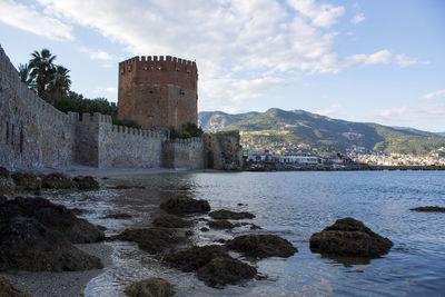 Alanya historic building by sea against sky