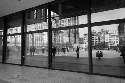 People in city seen through glass window
