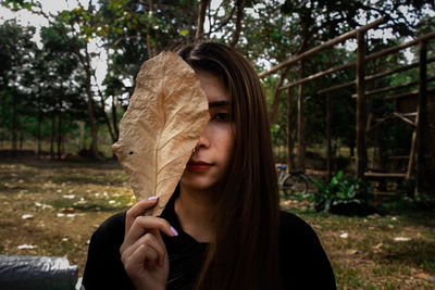 Portrait of a young woman holding a tree