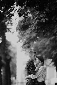 Couple kissing against trees