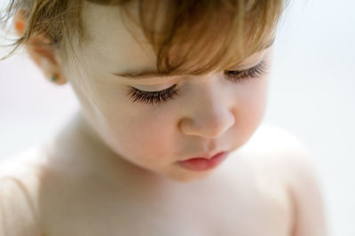 Close-up of shirtless girl against white background