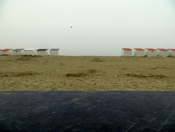 Lifeguard hut on sand against clear sky