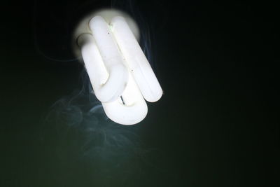 Close-up of light bulb over black background