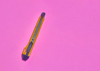 High angle view of colored pencils on pink table