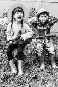 Cute girl singing while sitting with brother at yard