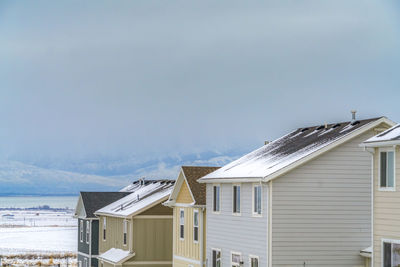 Houses by building against sky during winter