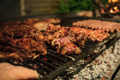 Close-up of meat on barbecue grill at night