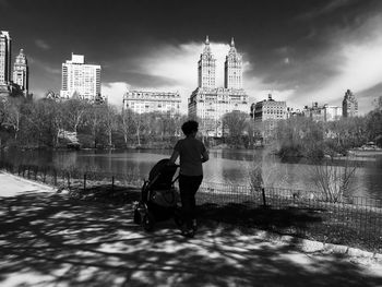 Woman standing by river in city