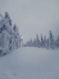 Snow covered landscape against sky