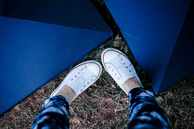 Low section of woman wearing shoes by tent on field