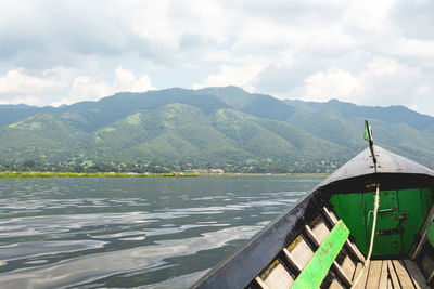 Scenic view of lake by mountains against sky