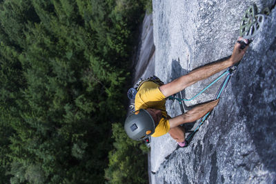 Man placing pro while climbing wide crack granite on squamish chief