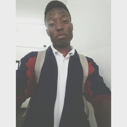 Portrait of young man standing against wall