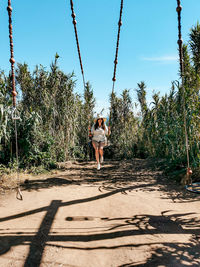 Young woman, girl on a swing, outdoors, tropical, summer, plants.