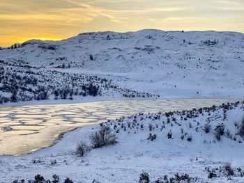 Scenic view of snowcapped mountains against sky during sunset