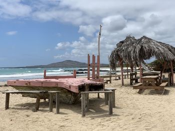 Chairs on beach against sky