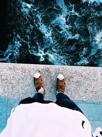 Low section of man standing in sea