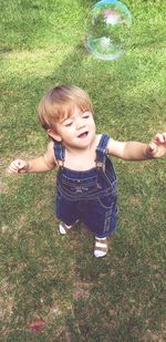 Boy with bubbles on grass in field