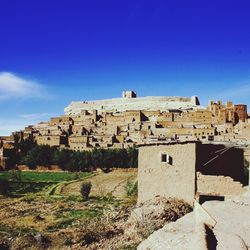 Stone houses in historic city against blue sky