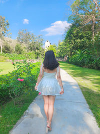 Rear view of woman walking on road