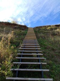 Steps leading towards landscape against sky