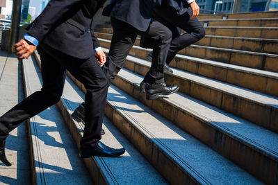 Low section of men moving up on steps in city